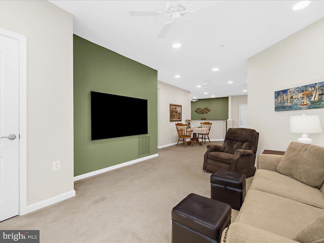 carpeted living room with ceiling fan