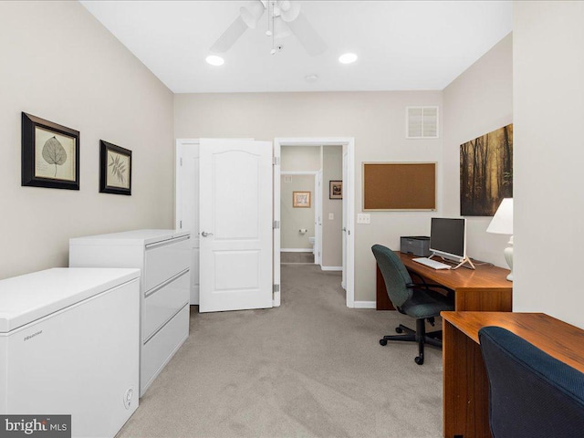 carpeted home office featuring ceiling fan