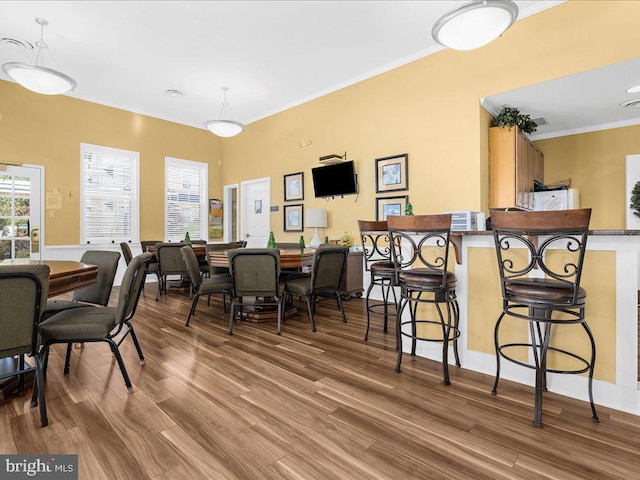 dining space featuring light hardwood / wood-style floors, plenty of natural light, and crown molding