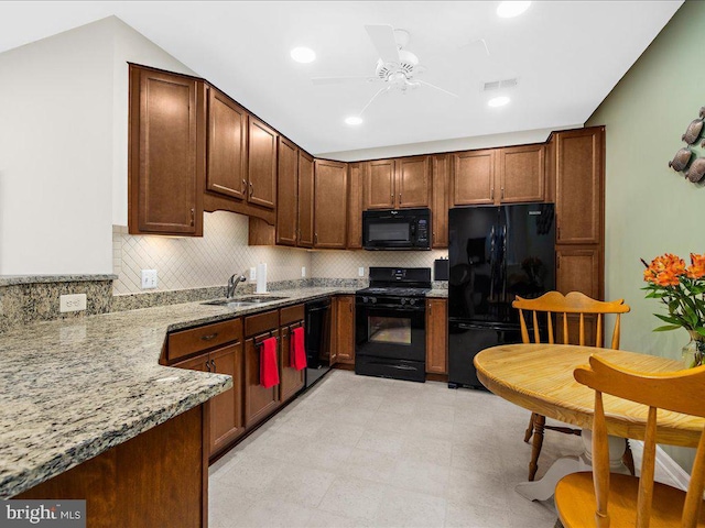 kitchen featuring ceiling fan, sink, light stone counters, backsplash, and black appliances