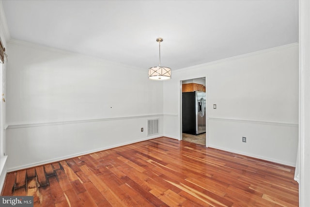 unfurnished room featuring crown molding and hardwood / wood-style floors