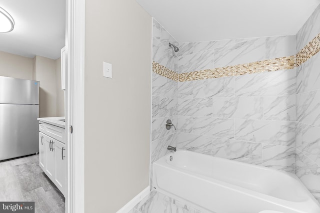 bathroom featuring vanity, hardwood / wood-style flooring, and tiled shower / bath