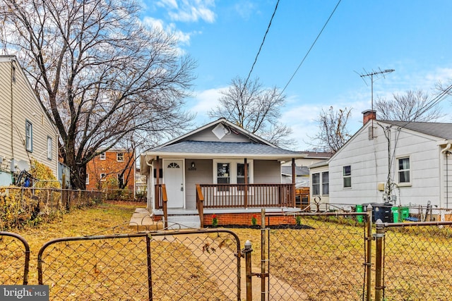 bungalow-style house featuring covered porch and a front yard