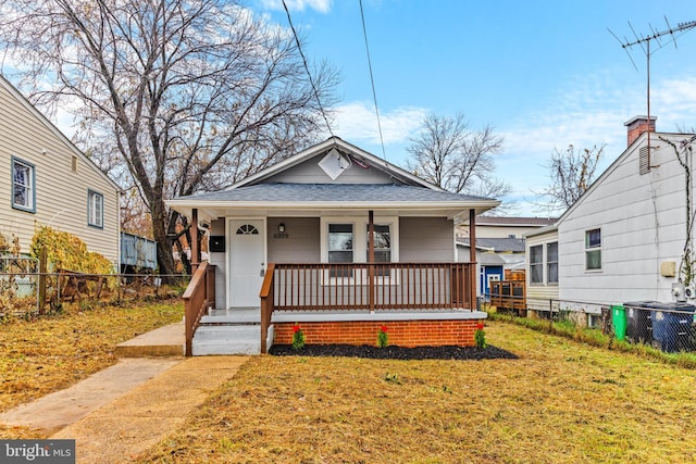 bungalow-style home with a front lawn, covered porch, and central AC unit