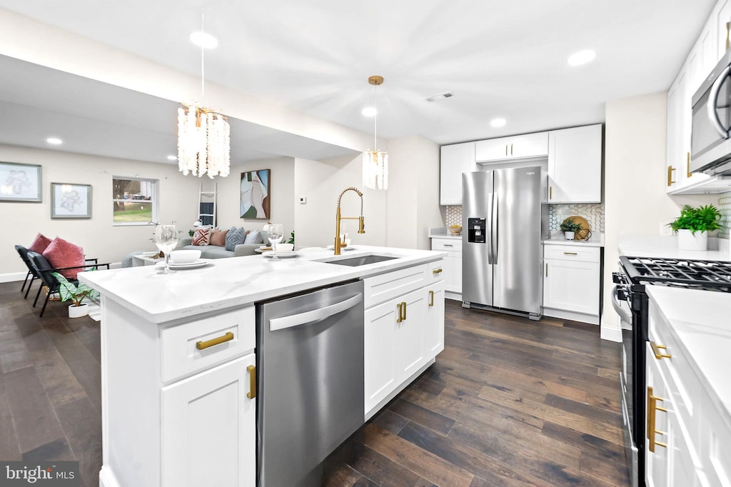 kitchen with white cabinets, appliances with stainless steel finishes, dark hardwood / wood-style floors, and sink