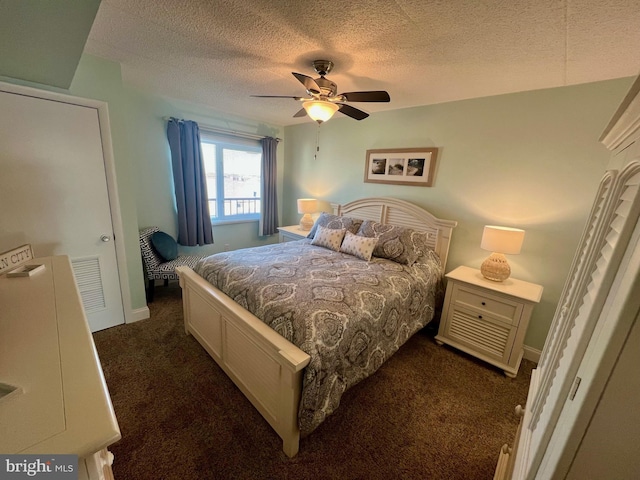 bedroom with dark colored carpet, a textured ceiling, and ceiling fan