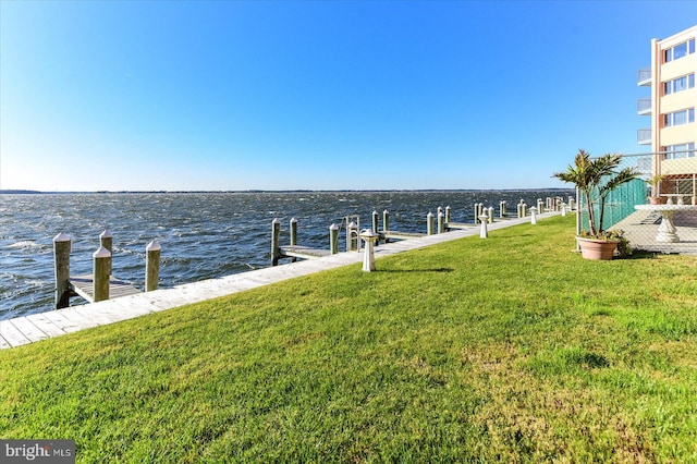 dock area featuring a lawn and a water view