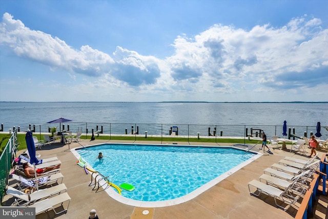 view of pool with a patio and a water view