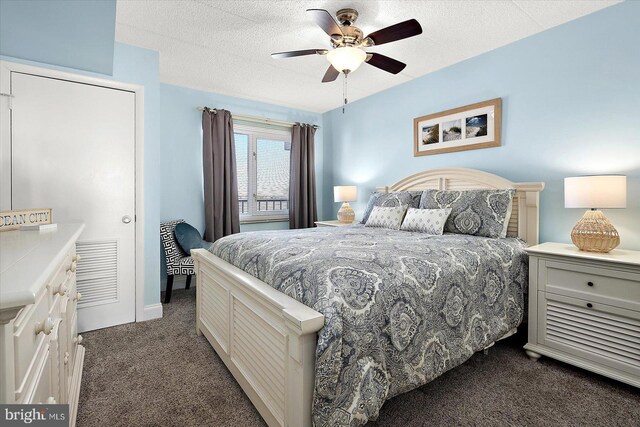 carpeted bedroom featuring ceiling fan and a textured ceiling