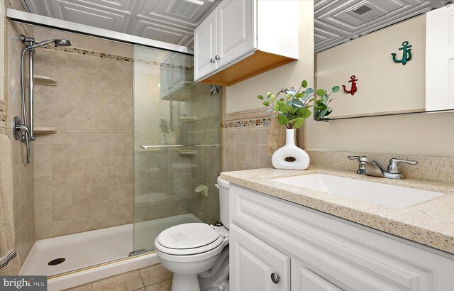 bathroom featuring toilet, vanity, tile patterned floors, and an enclosed shower