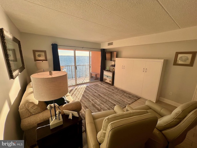 living room with a water view and a textured ceiling