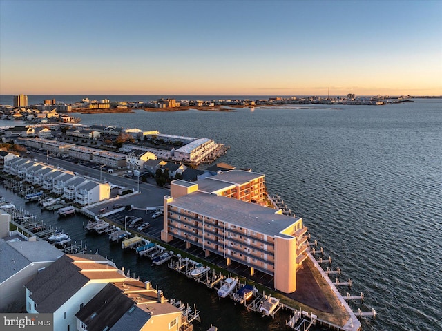 aerial view at dusk featuring a water view