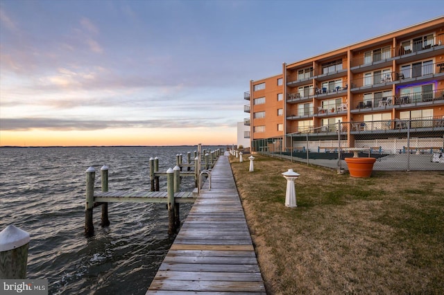 dock area with a yard and a water view