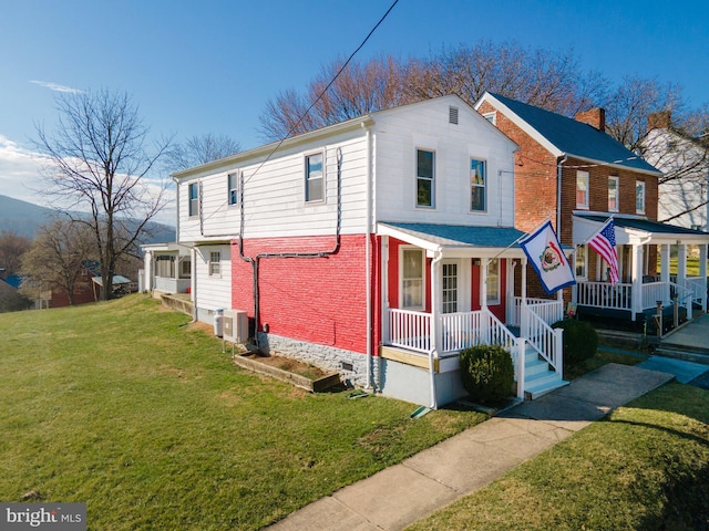 view of front of property with covered porch, a front lawn, and central air condition unit