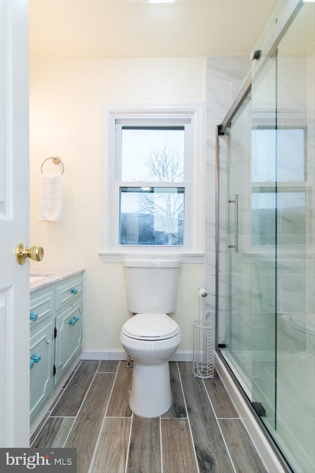 bathroom with vanity, toilet, and an enclosed shower