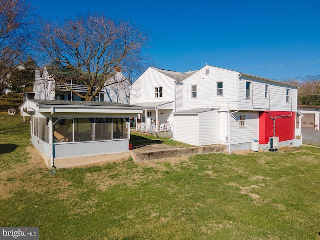 rear view of property featuring a yard and a sunroom