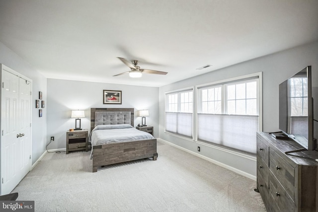 carpeted bedroom with ceiling fan and multiple windows