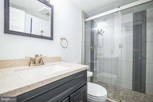 bathroom with vanity, an enclosed shower, and toilet