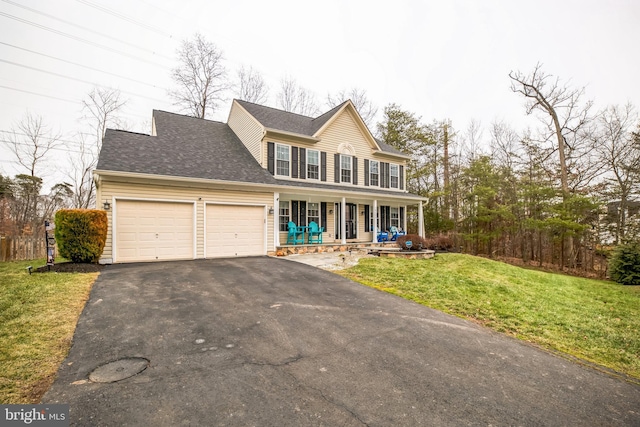 view of front facade featuring a garage, a front yard, and covered porch