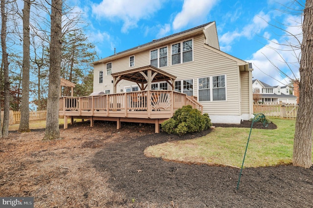 back of property featuring a wooden deck, a yard, and a gazebo