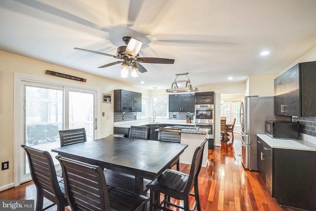 dining room with dark wood-type flooring, ceiling fan, and sink