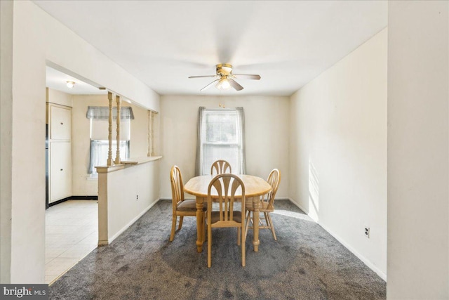 dining space featuring ceiling fan and light carpet