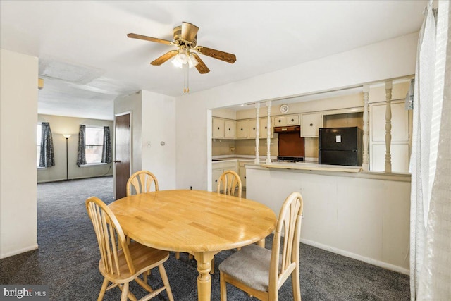 dining area with ceiling fan and dark carpet