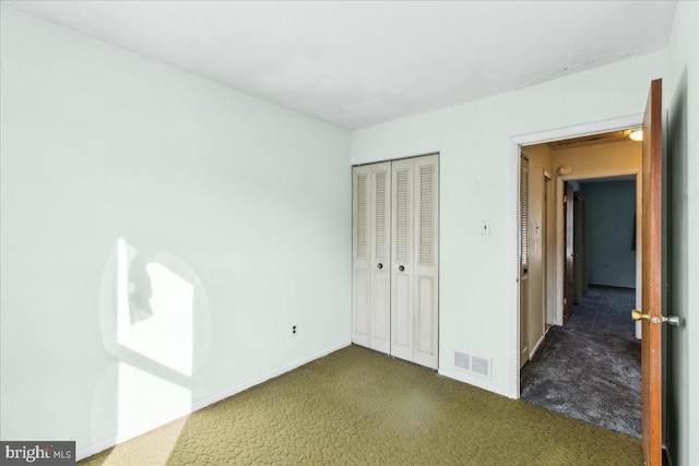 unfurnished bedroom with dark carpet and a closet