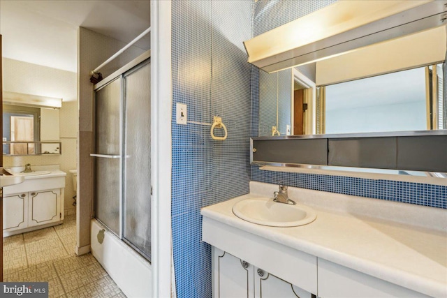 bathroom featuring shower / bath combination with glass door and vanity