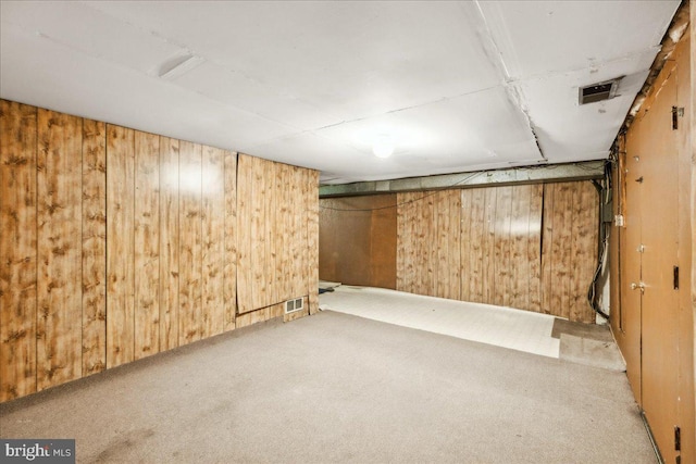 basement with wooden walls and light carpet