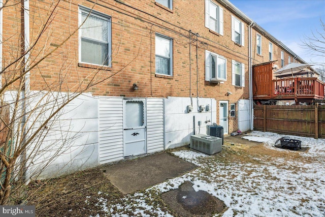 snow covered rear of property with central AC