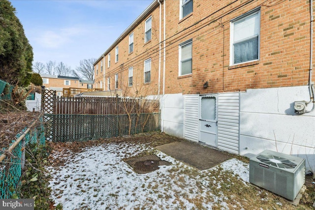 snowy yard featuring central AC