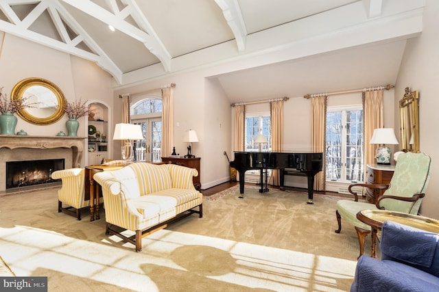 sitting room featuring beam ceiling, light colored carpet, and a premium fireplace