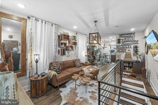 living room with a notable chandelier and dark hardwood / wood-style flooring