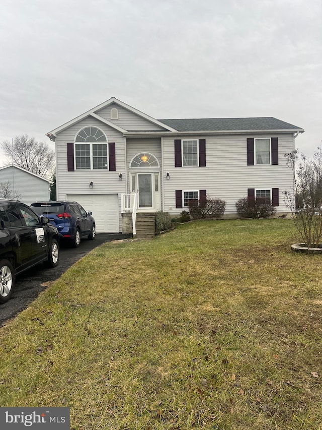 split foyer home featuring a front yard and a garage