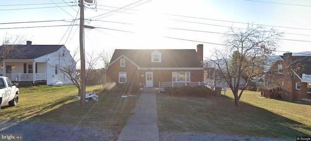 new england style home featuring covered porch and a front yard