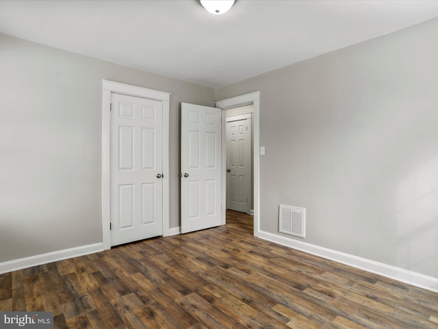 unfurnished bedroom with dark wood-type flooring