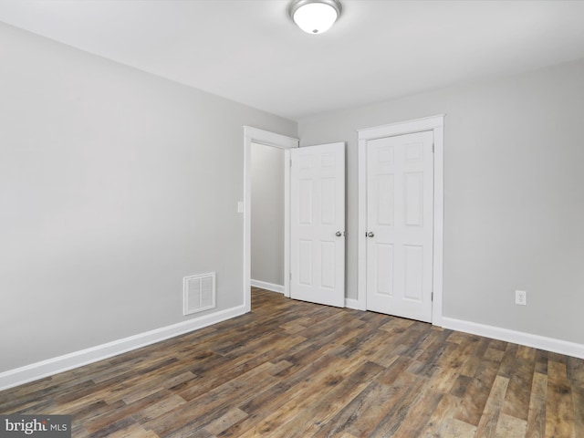 unfurnished bedroom featuring dark hardwood / wood-style flooring