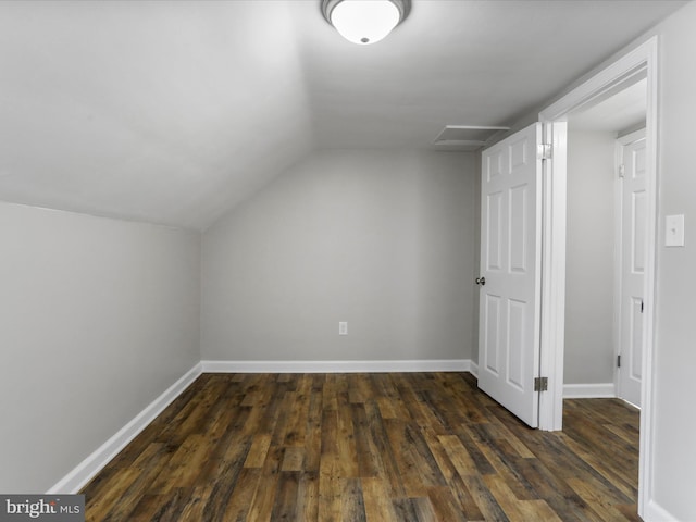 bonus room with dark wood-type flooring and vaulted ceiling