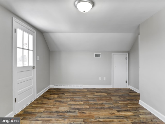 bonus room with dark wood-type flooring, a baseboard heating unit, and vaulted ceiling