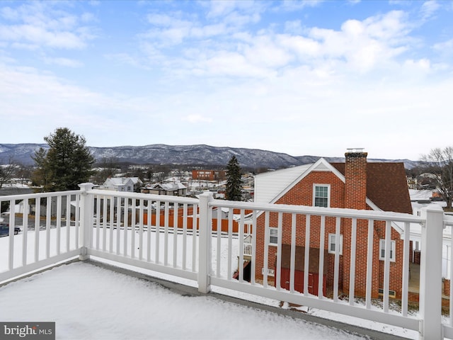 snow covered back of property with a mountain view