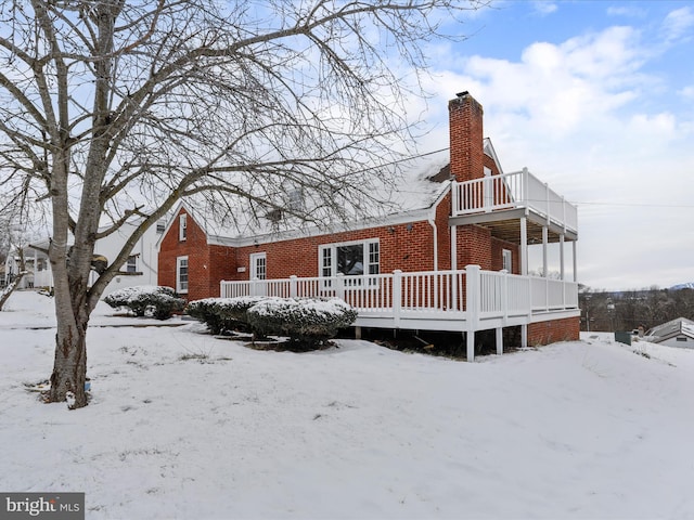 snow covered house featuring a deck