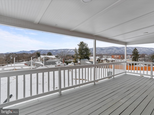 snow covered deck with a mountain view