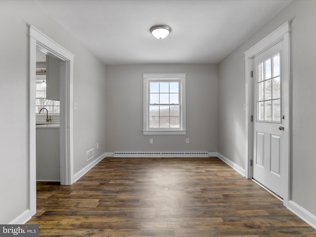 spare room with sink, dark hardwood / wood-style floors, and baseboard heating