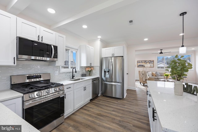 kitchen featuring white cabinetry, sink, pendant lighting, and appliances with stainless steel finishes