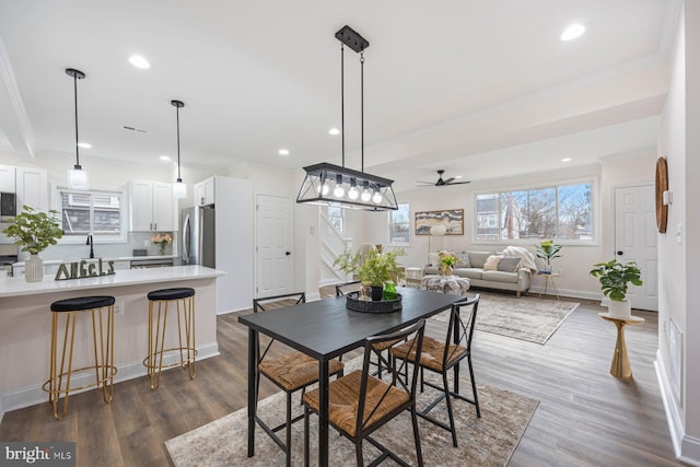 dining room featuring ornamental molding, ceiling fan, and dark wood-type flooring