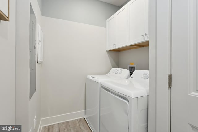 clothes washing area featuring cabinets, light hardwood / wood-style floors, and washing machine and dryer