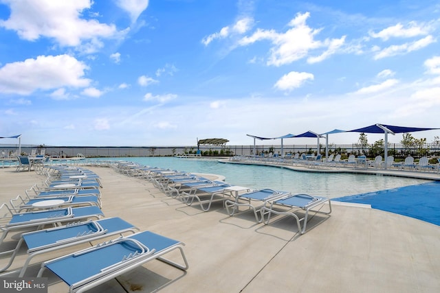 view of swimming pool with a water view and a patio area