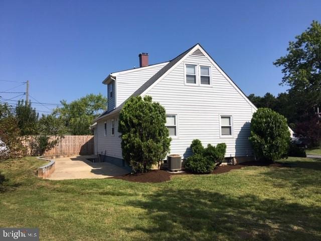 view of property exterior with a lawn, central air condition unit, and a patio