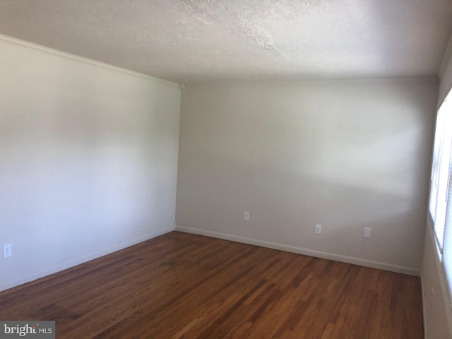 unfurnished room with a textured ceiling and dark wood-type flooring